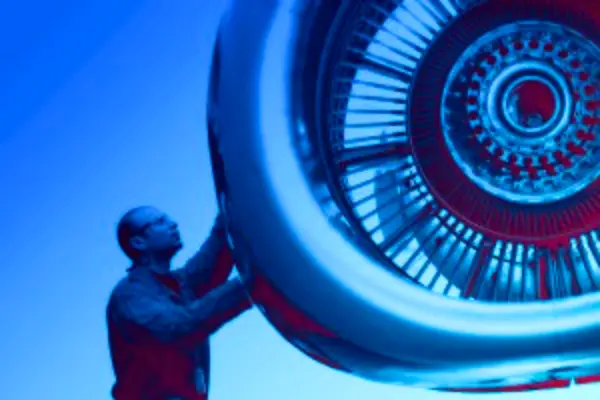 Man inspecting airplane turbine